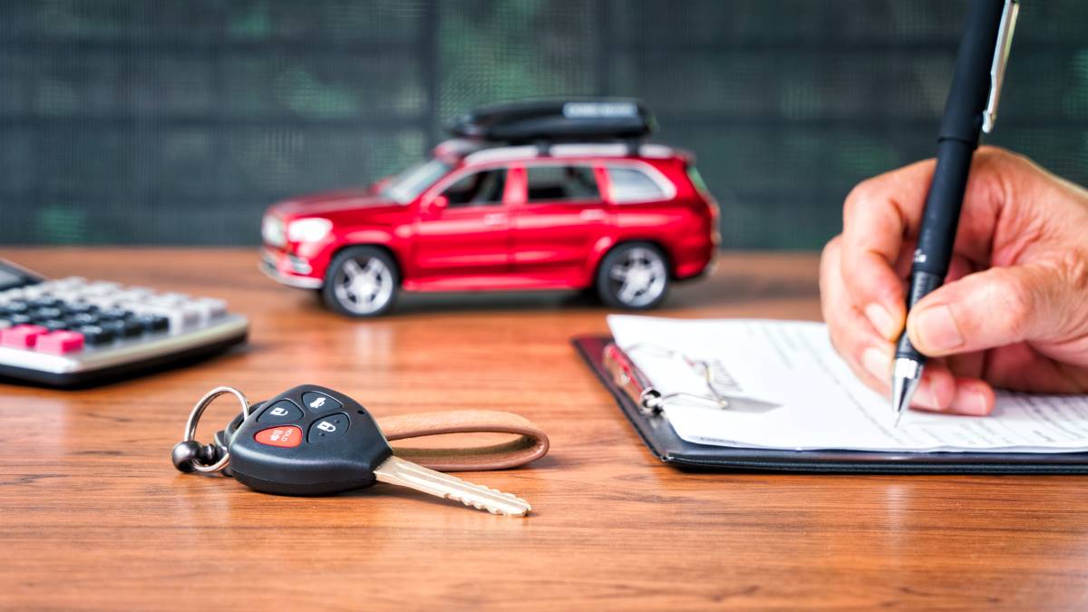 Clefs de voiture, calculatrice et contrat d'assurance auto sur un bureau avec un modèle de voiture rouge pour obtenir la carte verte